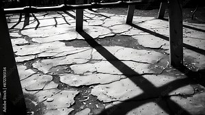 The plastic monkey bars cast ominous shadows on the cracked pavement. Black and white art