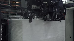 Offset printing press, industrial machine moving the paper material. Print house. Close-up. 4k footage.