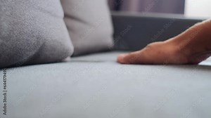 Close-up of male hand pressing light sofa for comfortable sitting at home or hotel. Checking hardness and softness. Choice of best type and quality. Selective focus
