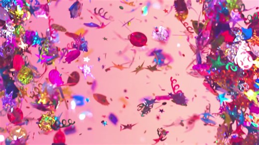 A colorful mix of several confetti shapes and colors falling in slow motion over a pink background - Free Stock Video