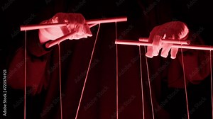The puppeteer controls the puppets in the theater in red neon light close-up. Managing people at work, in politics and government. Action control