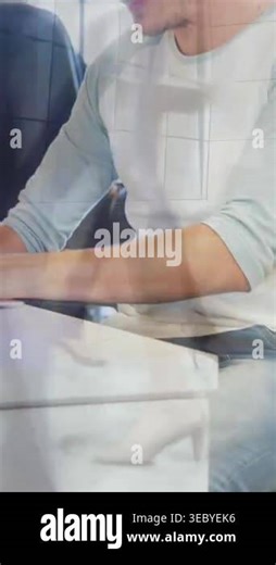 Vertical video: Man reaching laptop, typing and using mouse in office, grid glare while working. Professional, workstation, computer, daylight, reflections, glass, vertical video Stock Video Footage - Alamy