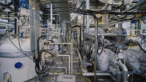 Chemical plant inside. Modern equipment, steel tanks and boilers with cables, pipelines and valves for chemical mixing. Production of anti-turbulent additives used in the oil industry.