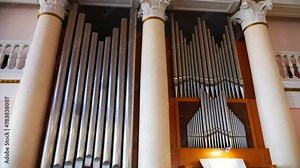 Ornate pipe organ filling a grand church with music. Towering pipes creating a majestic backdrop in a church. Intricate design of a colossal church pipe organ. Impressive pipe organ commanding attenti
