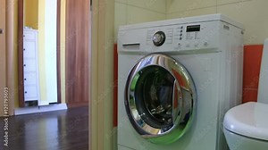 small child puts laundry in the washing machine