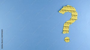 Stop motion - Footage of a moving question mark made from torn paper on a blue background with copy space. Concept of questions, quiz, riddle, faq, uncertainty and background. 4K mp4 high quality