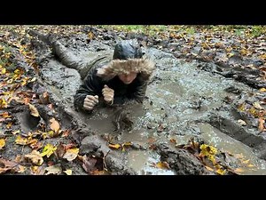 Shiny snowsuit with fur hood ind forest mud