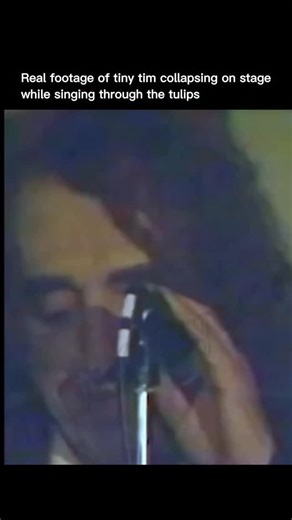 Explaining Past on Instagram: "Real footage showed Tiny Tim collapsing on stage while singing Through The Tulips during a live performance in 1996. The video captured an unedited moment from a concert in Minneapolis where he continued singing despite visible physical distress. Moments later, he collapsed and received emergency medical attention in front of the audience. Tiny Tim had a known history of heart problems, and the incident occurred months after a heart attack earlier the same year. He