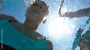 Child learn diving underwater in open air pool. A pretty child in swimsuit learn diving underwater in the home pool during summer holidays.