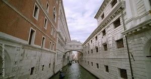 Gondoliers take tourists on gondola rides past one of the most famous bridges in the world called The Bridge of Sighs or Ponte dei Sospiri in Italian