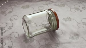 Agitated home fly trapped inside glass jar running in circles and cleaning itself
