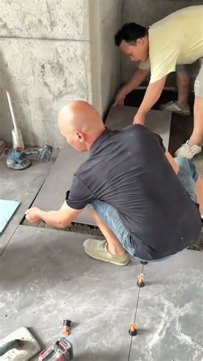 the process of installing ceramic tiles on the floor in the corner of a building #construction