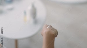 Cosmetics road kit. Young black lady applying lotion on hands, using small tube, making wellness procedures on vacation