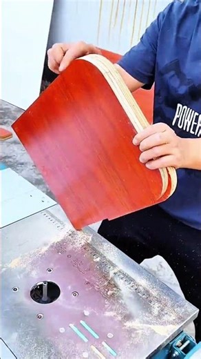 Router table setup positions laminated wood near spinning bit for shaping