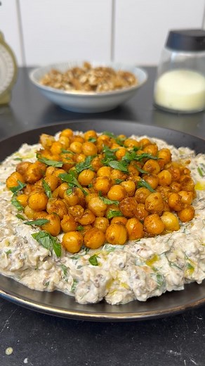 Auberginen Sesam Paste mit gerösteten Kichererbsen Rezept Paste 2 Auberginen Gute Hand voll frische Petersilie Gute Hand voll Walnüsse 4 EL griechischer Joghurt 2 EL Tahin ( Sesam Paste ) 1 Knoblauchzehe Spritzer Zitronensaft Salz Rezept Topping 3 EL Öl 130g vorgekochte Kichererbsen aus der Dose 1 TL Salz, Paprika, Pfeffer, Kreuzkümmel Zubereitung: Aubergine halbieren, mit einem Messer einstechen und mit ausreichend Öl bepinselt für ca. 20-25 Minuten bei 190 Grad Umluft in den Ofen geben. Anschl