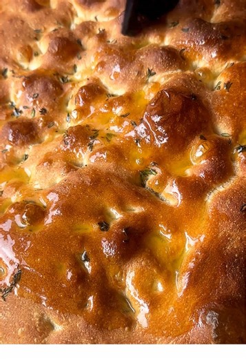 Honey butter thyme focaccia. The most pillowy, fluffy bread, with crispy edges, glazed with a sweet and salty butter. 500g lukewarm water 30g honey 10g yeast 625g bread flour 10g salt 15-20g sprigs of thyme, 40g butter, melted 75g olive oil Stir 15g of honey into the lukewarm water to dissolve. Stir in the yeast, leave for 5 minutes and then stir again. Combine the flour, salt and leaves from 10-13 sprigs of thyme in a large mixing bowl. Make a well in the centre and pour in the water mix, then 