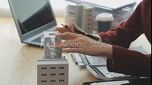 Person Hand Doing Property Tax Calculation Using Calculator Of House Model