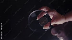 examination of a 2 euro coin under a magnifying glass on a black background close-up