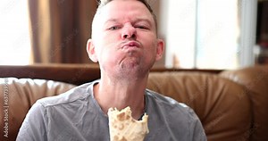 Man eats delicious shawarma with chicken meat. Fast food and takeaway street food