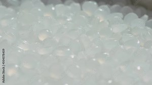 Plastic pellet close up and pan. Raw material for plastic compounding process. Transparent polyethylene granules. Chemical compound. Chemistry themes.