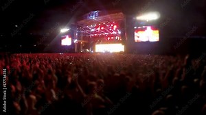 Thousands people standing in front of stage and clapping, rock band concert