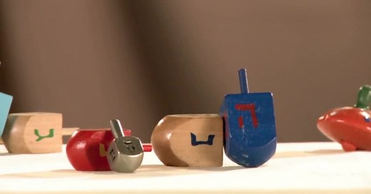 Why do we play with dreidels on Hanukkah?