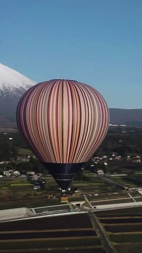 Some breathtaking footage of Cameron Z-105 G-PSLT, the iconic #PaulSmith Signature Stripe balloon, flown by pilot Ian Martin against a backdrop of Mount Fuji. 🇯🇵 What a sight! 🤩 🎥 : @paulsmithdesign / @paulsmithjapan #CameronBalloons #TeamCameron #paulsmithdesign | Cameron Balloons