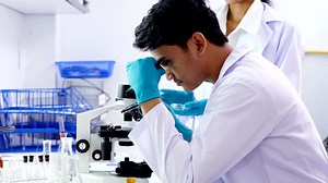 Male research scientist analyzing microscope slides in research lab. 4k Resolution. | Premium Stock Video Footage