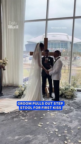 Groom pulls out step stool for first kiss with bride