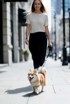 beautiful woman walking dog on street