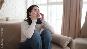 Upset young asian woman user customer using laptop feel frustrated mad about computer problem, stressed about mistake software error, worried reading bad news in social media sit on couch at home