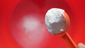 Pouring Washing powder from a plastic spoon