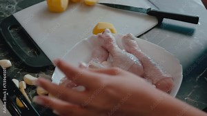Preparing potato wedges for baking on a tray lined with parchment paper, captured in a kitchen setting, ideal for a culinary tutorial or recipe sequence in a home cooking video series.
