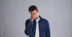Stress, burnout and face of tired man in studio with low energy, problem or exhausted on grey background. Fatigue, portrait and male model frustrated by brain fog, vertigo or mistake and conflict