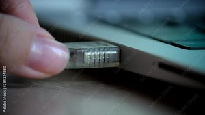 Laptop's USB Connector and USB Cable. Human hand sticks USB cable in to laptop. Process of inserting / attaching / removing or Pulling the USB Cable from USB Port. Closeup, Close-up, macro