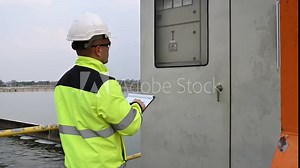 Electrical engineer man checking voltage at the Power Distribution Cabinet,preventive maintenance Yearly,Supervisor Working at a wastewater treatment plant