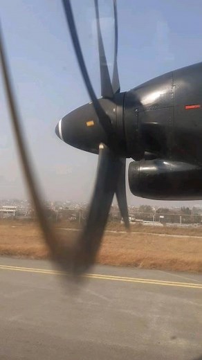 Propeller Aircraft taking off with aerial view of the ground below