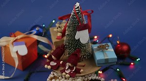 Christmas carousel with a Christmas tree and bright gifts. New Year's festive tree with gifts on the background of a bright garland.