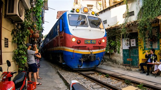 Watching a train travel between homes in Hanoi