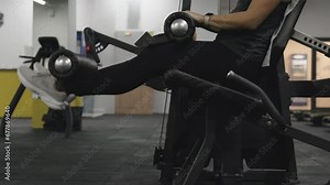 Young woman doing leg extension exercise on a seated machine. Stock Video