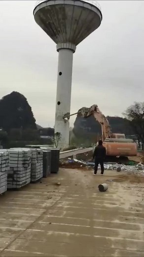 Excavator Demolition of Water Tower at Construction Site