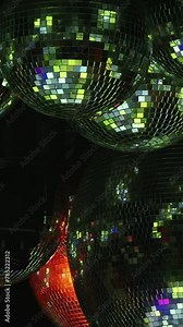 A series of blue disco balls are lit up in a dark room. Scene is energetic and fun, as the bright lights and colorful balls create a lively atmosphere. Vertical Nightclub video.