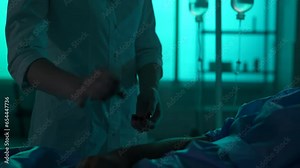 Close-up detail video of an unrecognisable woman, nurse, female doctor checking up on her patient laying in a hospital bed. She is checking his pulse.