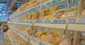 Supermarket, bread products are on display, products in a row. Loaves of bread, baguettes, loaves lie in a closed bakery window. Bread department of the supermarket. 4k, ProRes