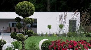 Front yard, landscape design With multicolored shrubs intersecting with bright green lawns Behind the house is a modern, garden care service, green grass with a beautiful yard for the background.