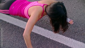 Fitness woman push ups on city road. Closeup of female athlete doing push up exercise. Top view of sport woman pushing on asphalt road. Close up of sporty woman fitness workout outdoor. Woman pushups