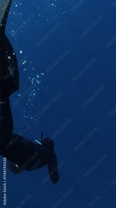 Underwater Slow Motion Footage of Free Diver Exploring Deep Ocean. Free Diving Recreation Sport. Vertical Aspect Ratio.