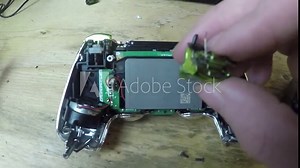 Fixing a circuit board inside of a video game controller.