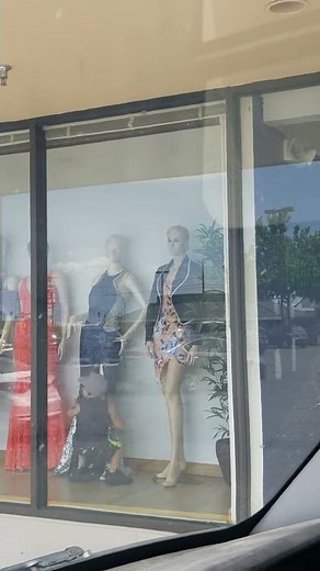 Little boy caught looking up mannequin dresses
