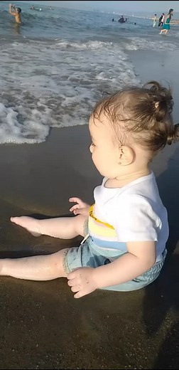 Toddler Enjoys Beach Playtime with Waves